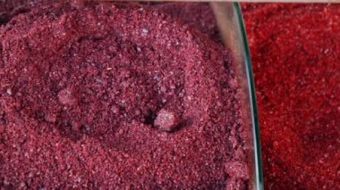 Zarif cam kaplarda güzelce sergilenen renkli kırmızı ve mor baharat tozları.