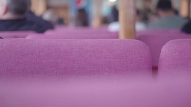 Feribotta içinde yolcular olan pembe koltuklar.