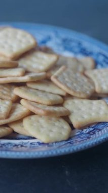Enfes bir yakın plan görüntüsü var. Krakerler, göz kamaştırıcı mavi bir tabakta güzelce dizilmiş.