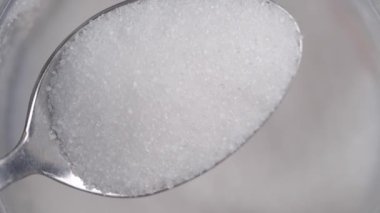 Karşıtlık olarak küçük bir kaşık beyaz şeker yumuşak bulanık bir zemin üzerine kurulur