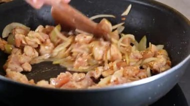 Kızartma tavasında, gerçekten lezzetli bir yemek yapmak için soğanla birlikte tavuk pişiriyoruz.