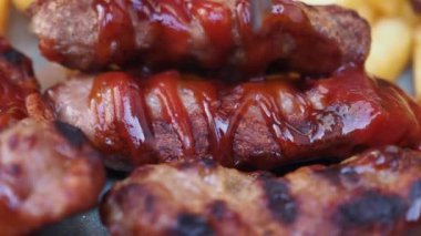 Ketçaplı ızgara et ve kızarmış patates..