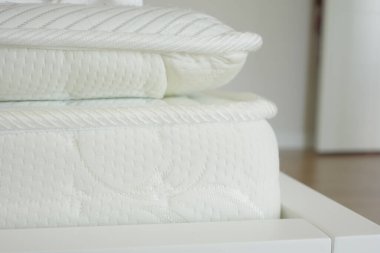 Örgü desenli ve nötr tonlu beyaz bir yatak yakın çekim görüntüsünde rahat bir deneyim sunar.