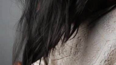 Küçük bir çocuk yumuşak saçlarını yumuşak elleriyle sallıyor, masumiyetini ve sıcaklığını gösteriyor.