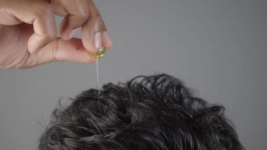 Erkekler saçlarına kapsül yağı sürüyor. .
