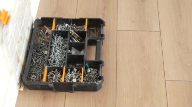 Vidalar ve matkaplarla dolu bir alet çantasıyla ahşap döşeme..