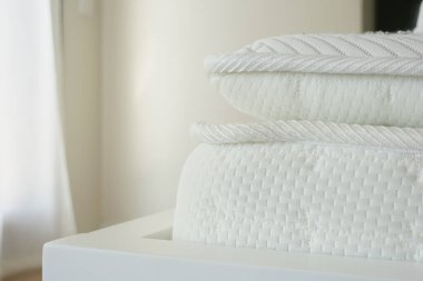 Örgü desenli ve nötr tonlu beyaz bir yatak yakın çekim görüntüsünde rahat bir deneyim sunar.
