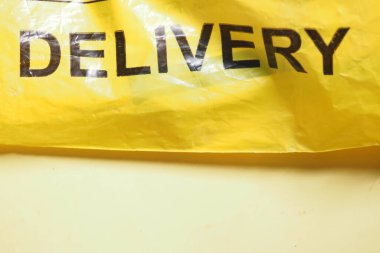 A vibrant yellow delivery bag with clear lettering showcases the delivery service brand clipart