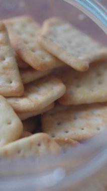 Kenarına kadar çeşitli krakerlerle doldurulmuş cam bir kavanozun detaylı bir görüntüsü.