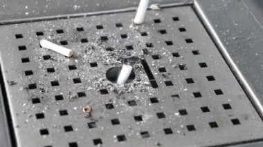 Metal bir kül tablasında büyük bir sigara izmariti koleksiyonu.