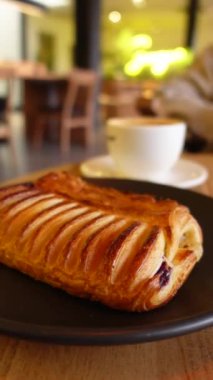 Sıcak bir hamur işi ve hoş, rahatlatıcı bir kafe ortamında bir fincan kahvenin tadını çıkar.