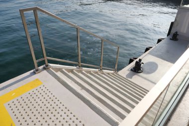 Aşağıdaki sakin sulara inen sağlam bir merdiven zarif metal parmaklıklar tarafından çerçevelenir.