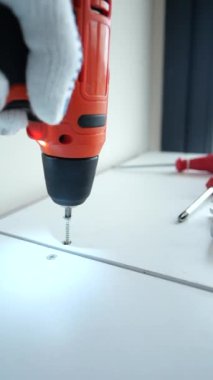 Bir el ustalıkla metal bir parantezi bu yakın planda temiz, beyaz bir yüzeye yerleştirir.