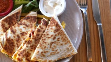 Salsa, ekşi krema ve salatalı Quesadilla.,