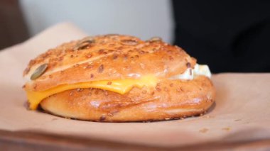 Ağzını sulandıran çedar peynirli sandviçin içine tıkıştırılmış mükemmel kızarmış bir zanaatkar çöreği.