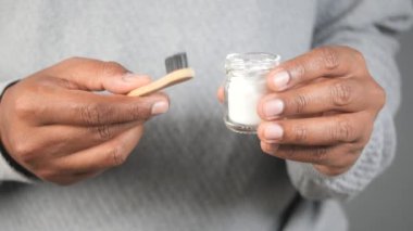 Elinde bir kavanoz kabartma tozu, bambu bir diş fırçası vardı. .