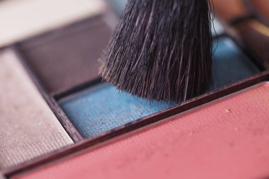 Göz farları ve makyaj fırçası olan bir palet. 