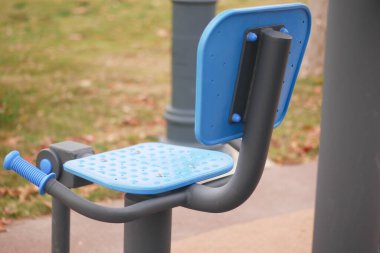 Bir parkta açık hava egzersizleri yapmak için tasarlanmış modern bir egzersiz istasyonu.