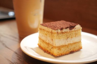 Taze buzlu kahveyle servis edilen bir dilim tiramisu keki..