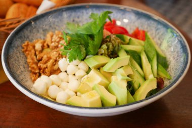 Canlı bir salata kasesinde taze sebzeler ve malzemeler var..