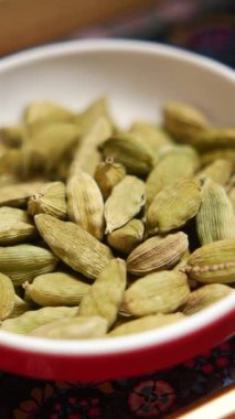 Bir kasede dizilmiş taze yeşil kakule kapsüllerinin yakın görüntüsü.