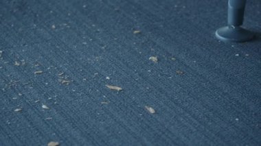 Toz ve döküntüler tekstil yüzeyinin her tarafına saçılmış.