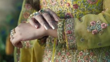 Yüzük ve bilezik de dahil olmak üzere özenle dekore edilmiş bir elin yakın çekimi.