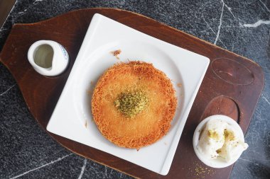 kunafa with a wipe cream on a plate