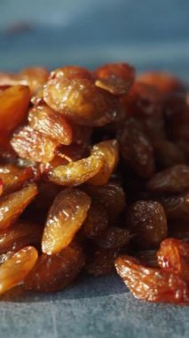 Kalıplı bir yüzeyde parıldayan altın kuru üzümlerin detaylı bir görüntüsü.