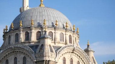 Çarpıcı bir kubbe, açık mavi gökyüzüne karşı karmaşık tasarım ve altın aksanlar sergiliyor..