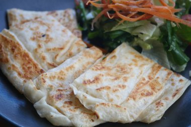 Baharatlı ekmek, içinde yeşil sebzeler ve doğranmış havuçlar bulunan cömert bir tabak salatanın yanında lezzetli ve besleyici bir yemek oluşturur..