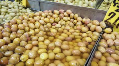 Canlı bir yerel piyasa salamura edilmiş çeşitli taze zeytinler sergiliyor. Tüccarlar, zengin renkleri ve cazip aromaları olan alıcıları cezbederek seçimlerini sergiliyorlar..