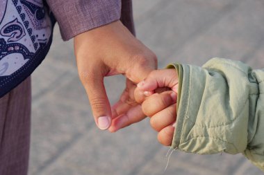 Bir ebeveyn ve çocuk yürürken sıcak bir anı paylaşıyor..