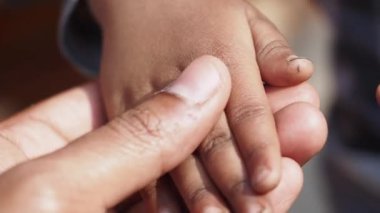 Bir yetişkinle bir çocuğun eli arasındaki nazik bir etkileşim neşe verir..