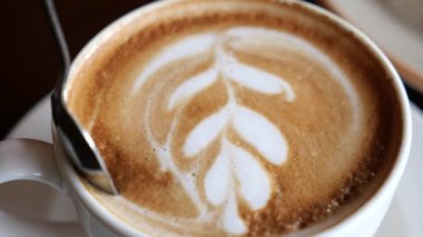 Sıcak bir kafe atmosferinde güzel latte sanatları yapan bir uzmana bakın..