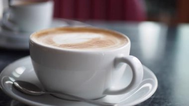 Huzurlu bir ortamda lezzetli bir latte yudumluyor..