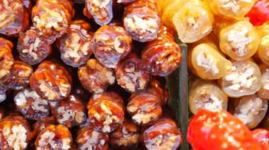 Renkli tatlılar kalabalık bir pazarda ziyaretçileri cezbeder.