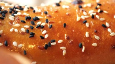 Siyah ve beyaz susam tohumlarıyla kaplı altın ekmek..