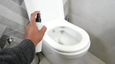 Birisi klozete temizleyici sıkar..