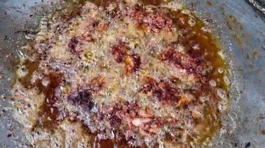 Cızırdayan ve kaynayan yağ kızarmış parçaları çevreledi.