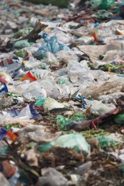 Dökülen plastik ve molozlar doğal bir alandaki zemini kaplıyor..