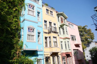 Parlak renkli binalar açık mavi gökyüzünün altında duruyor..