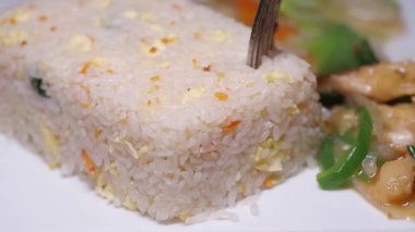 Lezzetli kızarmış pirinç renkli sebzeler ve tavuk parçaları ile sunulur..