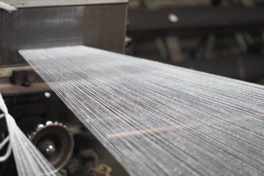 Üretim sırasında bir tekstil fabrikasında iplikler birbirine dokunuyor..
