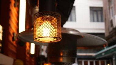 Sıcak bir ışık, büyüleyici bir yemek alanında, gece çökerken bir hoş geldin parıltısı saçar..