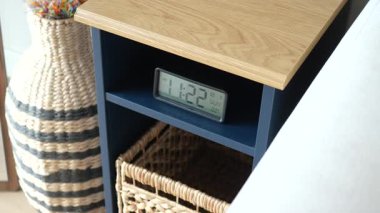 Saat 11: 22 ve dokuma sepetli şık bir komodin..