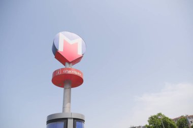 Uskudar metro istasyonunun parlak işareti mavi gökyüzüne karşı duruyor.