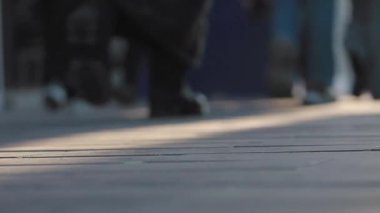 Kalabalık, güneş batarken hareketli bir şehir kaldırımında geziniyor..