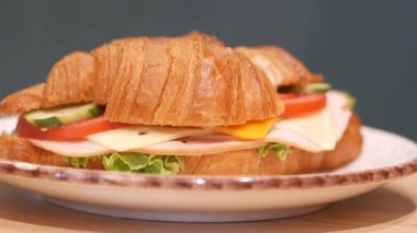 Jambon, peynir ve gevrek sebzelerle dolu lezzetli bir kruvasanın tadını çıkarın..