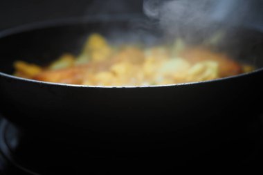 Kara tavada pişirilen lezzetli bir yemeğin buharı yükselir..